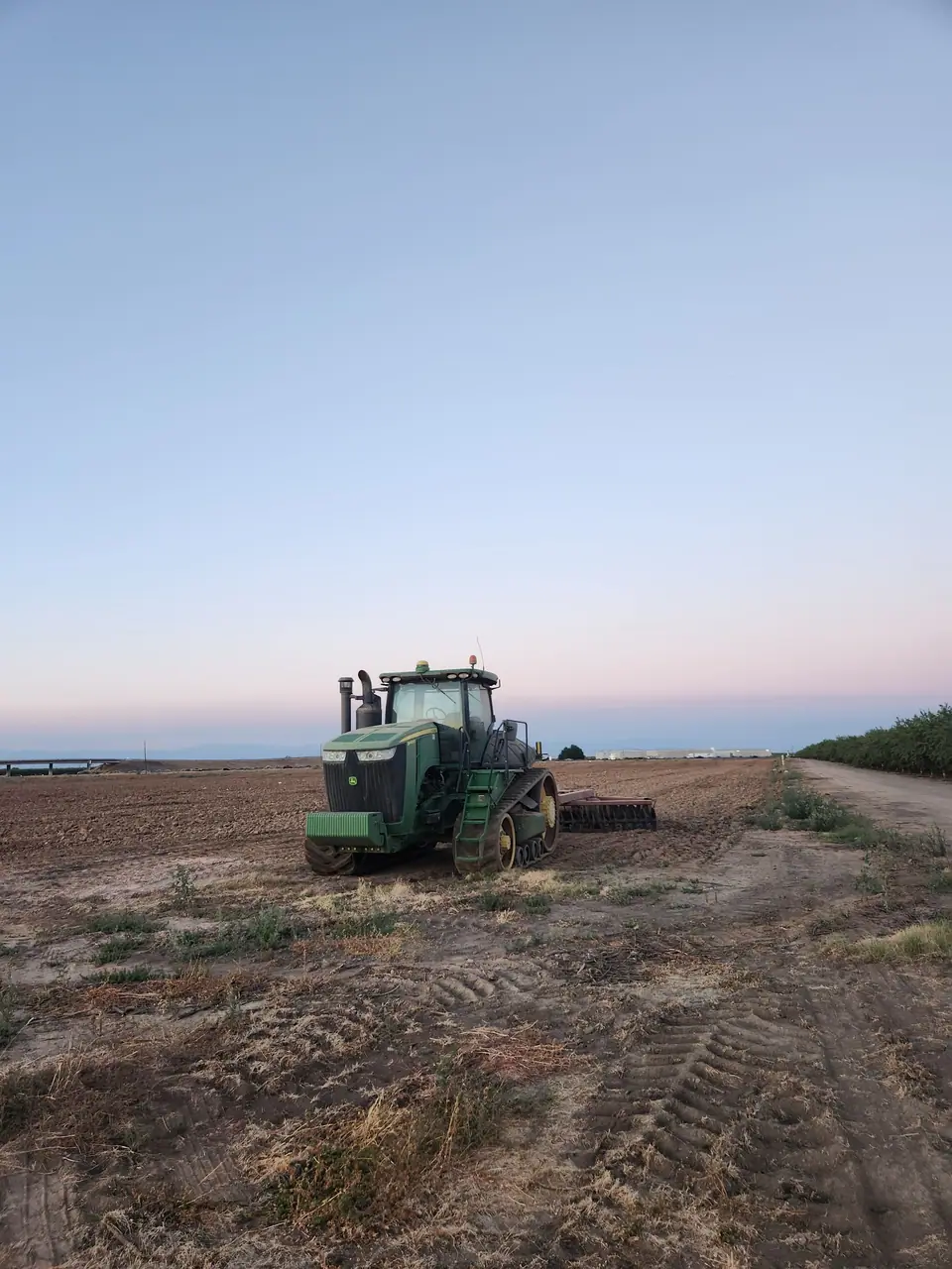 A tractor working a California field at dusk